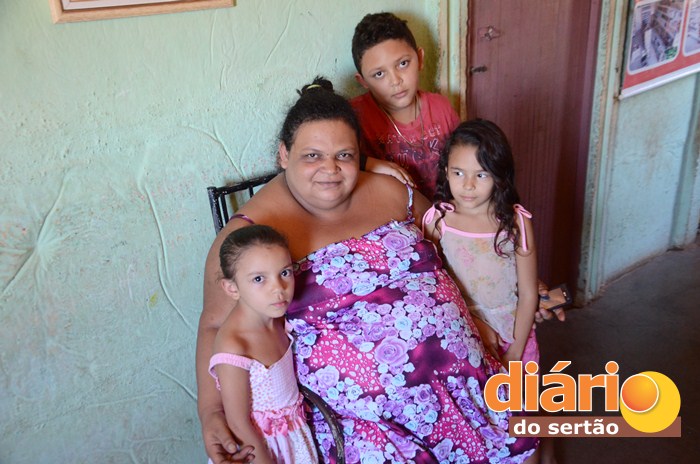 Mulher ao lado dos três filhos pequenos (foto Charley Garrido)