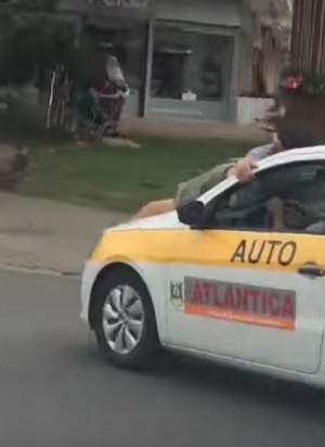 Vídeo mostra homem agarrado em capô de carro de autoescola (Foto: Reprodução/Youtube)